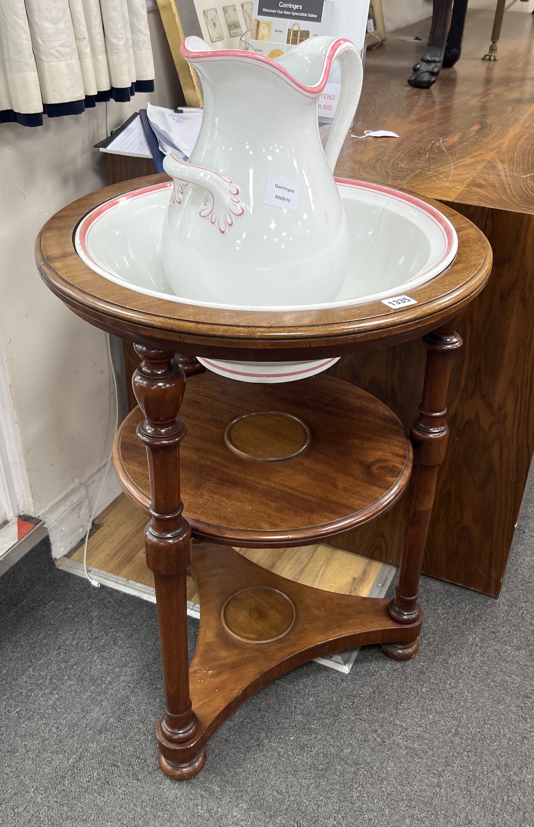 A Victorian circular mahogany three tier washstand with ceramic jug and basin, diameter 55cm, height 76cm